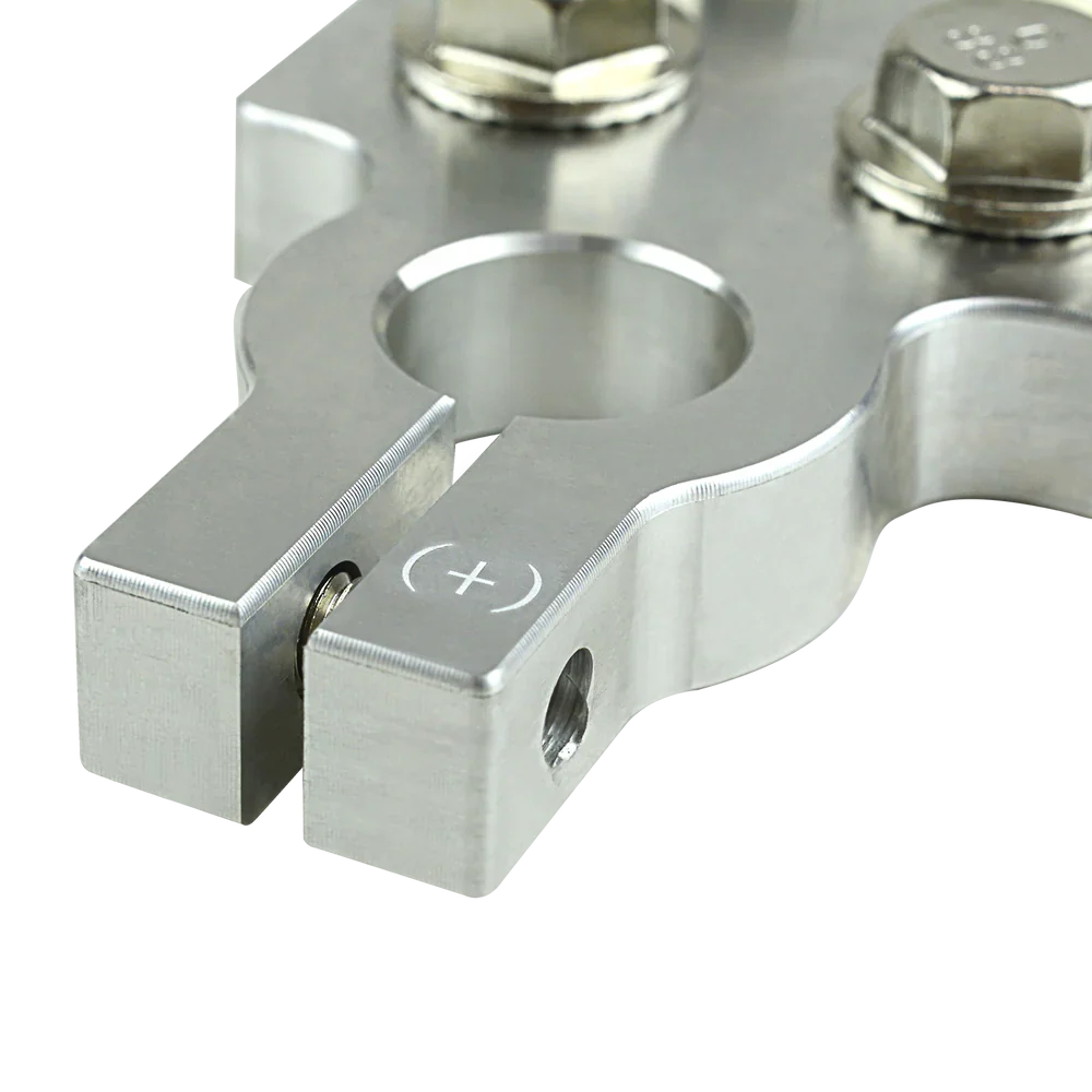 Positive battery terminal detail, brushed metal clamp with plus symbol and screw hole