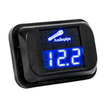 Audiopipe digital voltage meter with blue LCD display reading 12.xV, black housing